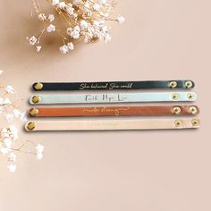 four personalized leather pencils on a table next to white flowers and baby's breath