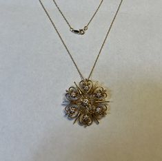 Featuring: A very beautiful older vintage (art deco era, early 1900's) pendant necklace . Both pendant and necklace are ALL made of solid 14K gold with 7 round cut white diamonds of very good quality. Diamonds total a little over 1/3 ct. Center diamond is about 1/10 ct and other diamonds are each nearly 1/20 cts (4 pts) Pendant has impressive earlier smith workmanship in an eye catching arts and crafts design . Has clasp pin in back which gives you option to wear as brooch . Clasp pin opens and Family Heirloom Necklace, Heirloom Necklace, Arts And Crafts Design, Art And Craft Design, Deco Vintage, Art Deco Era, Family Heirloom, White Diamonds, Quality Diamonds