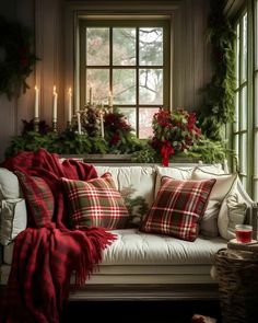 a living room filled with furniture and christmas decorations on the window sill, surrounded by greenery