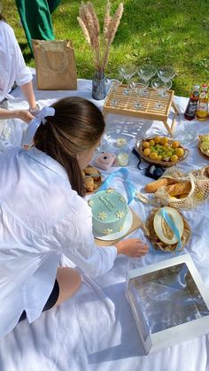 a woman in white shirt sitting at table with food