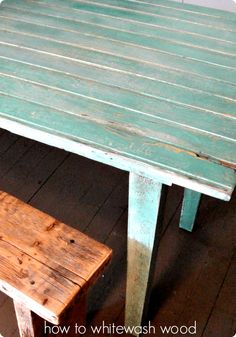 an old wooden table and bench are painted aqua blue with whitewash on the top