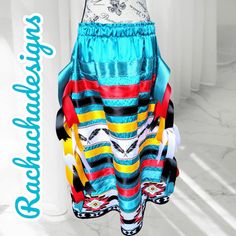 A Native American Real Indin Princess Ribbon Skirt, perfect for weddings, ceremony, Powwow, formal events, and more. This is a special piece I designed for that special occasion, made with 5 different colored ribbons: turquoise, red, black, bright gold, and white. The ribbons trail from both left and right sides in a total of 16 inches which is 8 inches on both sides which are cut in a V-shape to give this unique design. Gold braided trim above the duck cloth design, a special unique trim to cen Ribbon Skirts Native American, Indigenous Artwork, Ribbon Skirt, Native American Clothing, Ribbon Skirts, Cloth Design, Turquoise Print, American Princess, Princess Skirt