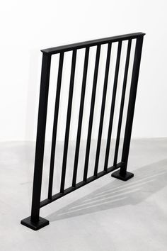 a black metal railing is shown against a white wall