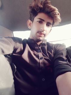 a young man sitting in the back seat of a car