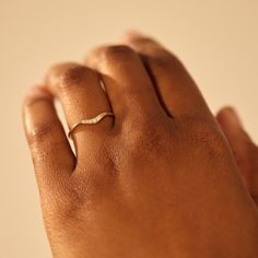 a woman's hand with a gold ring on her left hand and a diamond in the middle