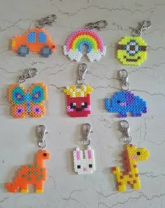 six keychains with different designs on them sitting on a table next to each other