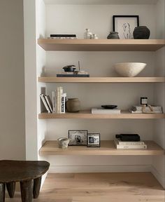 the shelves are filled with books and vases