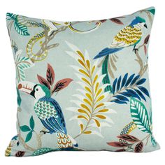 a blue pillow with colorful birds and leaves on the front, sitting on a white background