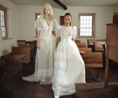 two women in white dresses standing next to each other