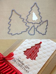 two christmas trees cut out of paper on top of a card with red ribbon and bow