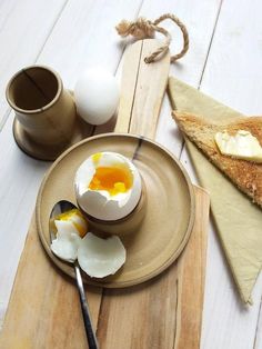 an egg is broken in half on a plate next to some bread and eggshells