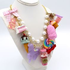 This kawaii statement necklace is called Pink Candy Shop and is a perfect cute charm jewelry gift for any woman in your life including your best friend (or yourself, let's be honest). This piece has been handmade from resin, clay and high quality metal components and features hand painted charms for a quality piece that will be a cute go-to in any charm lovers jewelry collection! Details & Measurements:-Handmade Necklace-High quality glass pearls-Hand-painted charms made from resin & polymer clay-Gumball machine has free floating beads inside! (note it is partially made from glass and fragile)-Choose Gold or Silver Finish -Choose 5, 7 or 9 charms (see list below to find out what charms come on each option)-Charms are chunky and are 1-2" in size (2.5-5cm)-19" (47.5cm) total Necklace Length- Pink Novelty Jewelry For Birthday, Playful Dangle Necklaces With Charms, Playful Dangle Charm Necklace, Playful Dangle Charms Necklace, Pink Fun Style Charm Necklace, Fun Pink Charm Necklaces, Whimsical Charm Necklaces For Birthday, Whimsical Charm Necklace For Birthday, Whimsical Charms Necklace For Birthday