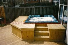 an outdoor hot tub on a deck with steps leading up to it and a sliding glass door