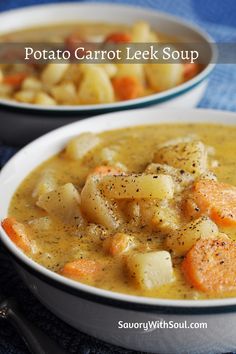 two bowls of potato carrot leek soup on a blue tablecloth with spoons