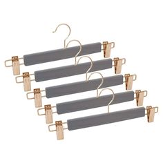 four gray and gold clothes hangers with clips