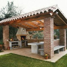 an outdoor kitchen and grill area in a backyard