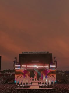 the stage is set up for a concert with people standing on it and lights in the background