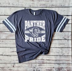 Introducing my Panthers school spirit lightweight jersey LAT tees, the perfect blend of softness, stretchiness, comfort, and cuteness! These tees are designed to elevate your school spirit wear to new levels of style and comfort. Crafted from high-quality lightweight material, these tees offer an exceptional softness that feels gentle against your skin. Embrace the comfort of these shirts, as they provide a cozy and luxurious feel that you'll never want to take off. The stretchy fabric ensures a perfect fit and allows for ease of movement. Whether you're cheering on your team or going about your day, these tees provide unrestricted comfort and flexibility. No more feeling constrained or uncomfortable in your school spirit wear! Shirts are unisex sizing - please see the size chart shown in Spirit Wear Shirts, Panthers Shirt, Panther Shirts, Mascot Shirt, School Spirit Wear, Shirt Football, Team Shirt, Spirit Wear, Team Shirts