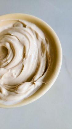 a bowl filled with cream sitting on top of a table