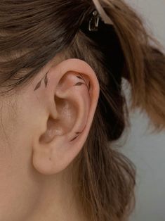 a woman's ear is shown with small black lines on the middle part of her left ear