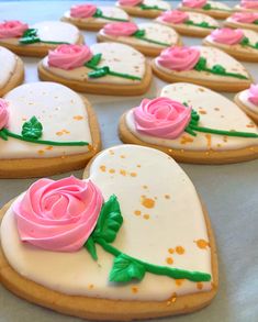 decorated cookies with frosting and pink roses on them