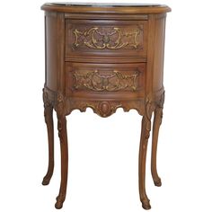 an ornate wooden side table with drawers