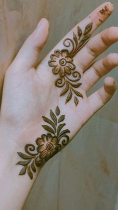 a woman's hand with henna tattoos on it