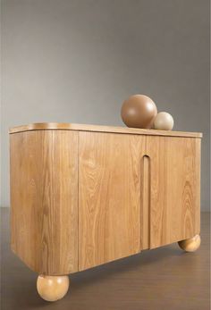 a wooden cabinet with two balls on top