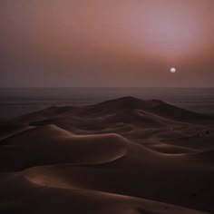 the sun is setting over sand dunes in the desert, with no people on it