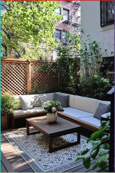 an outdoor living area with couches, tables and plants