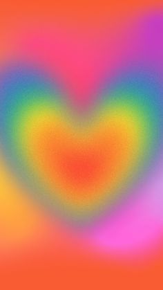 an image of a heart shaped object in the middle of a blurry background with orange, pink, yellow and green colors