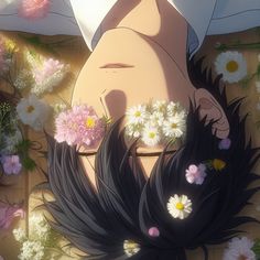 a woman laying on top of a wooden floor next to flowers and grass in front of her