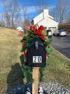 a mailbox decorated with evergreen and red bows