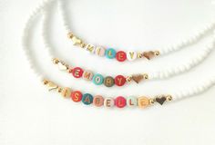 This darling name necklace is so sweet, colorful and surely will make a perfect birthday gift, Christmas gift or and every day favorite accessory  100% made to order and handcrafted with excellence and precision into a beautiful, personalized name necklace that is so special and perfect for gift giving. Arrives in a white gift box with a bow ready for gifting. The colorful beads are carefully chosen to form a random color design for a personalized style. We use strong stretch cord to string the beads on. Because this necklace is a stretchy it does not require a clasp which makes this beautiful, dainty, personalized name necklace easy to put on and easy to take off.  NECKLACE LENGTHS  12, 13 and 14 inches for toddlers and children  15, 16 and 18 inches for adults. MATERIALS  letter beads wh Bead Name Necklace, Beaded Name Necklace, Christmas Toddler, Necklace With Heart, Toddler Christmas, Letter Beads, White Gift Boxes, Beaded Necklaces, Toddler Kids