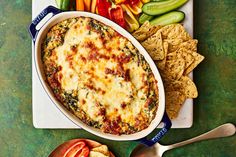 a casserole dish with vegetables and crackers on the side