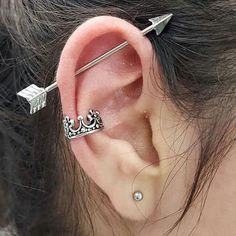 an ear piercing with two arrows attached to it's middle part, and a crown on top