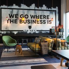 an office lobby with chairs, tables and a large sign that says we go where the business is