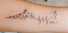 a person with a tattoo on their arm that has mountains in the shape of heartbeats