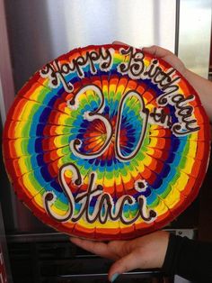 a person holding up a colorful plate with the words happy birthday 50 years on it