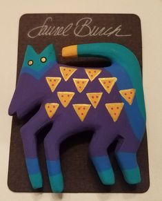 a blue and purple cat with slices of pizza on it's back is shown