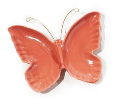 an orange butterfly shaped ornament on a white background