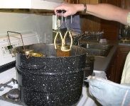 a person pouring liquid into a pot on top of a stove