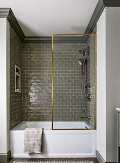 a bath tub sitting next to a shower in a bathroom on top of a tiled floor