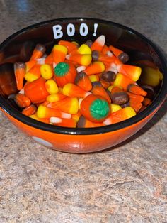 a bowl filled with candy corn on top of a counter