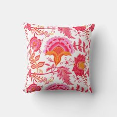 an orange and pink pillow on a white wall