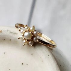 a close up of a ring with pearls on it