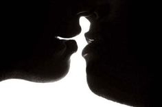 the silhouette of two people kissing each other