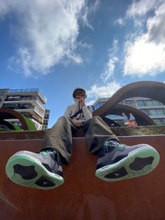 a person sitting on the edge of a skateboard ramp with their feet propped up