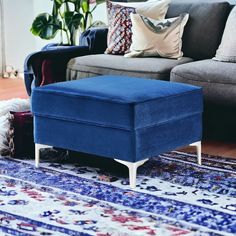 a blue ottoman sitting on top of a rug next to a couch