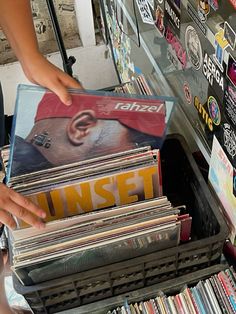 a person is picking up cds from a bin